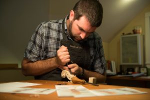 Owner of Garth Lee Strings, Garth Lee carefully shapes violin, and viola scrolls by hand.